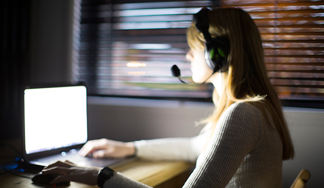 Women wearing headphones and working on laptop